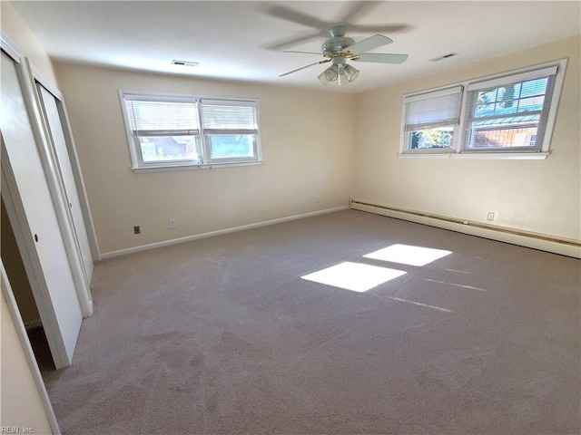 carpeted spare room featuring ceiling fan and a baseboard radiator