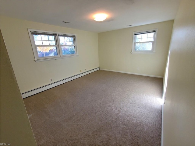 empty room featuring carpet floors, a baseboard radiator, and a wealth of natural light