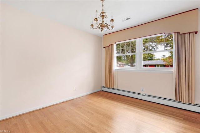 spare room with an inviting chandelier, a baseboard radiator, and wood-type flooring