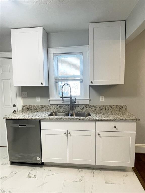 kitchen featuring light stone counters, white cabinetry, stainless steel dishwasher, and sink