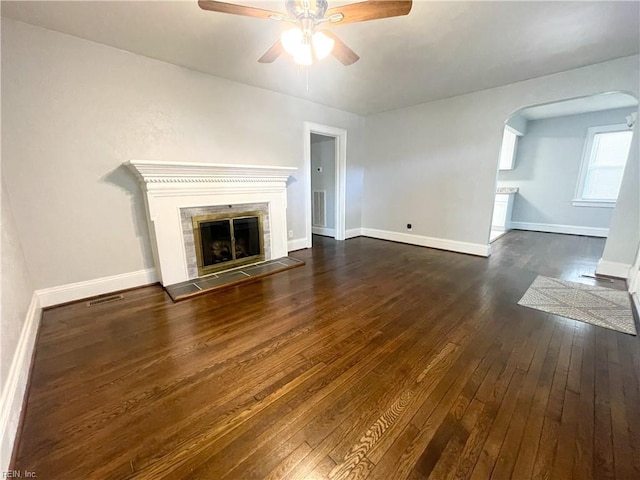 unfurnished living room featuring ceiling fan, dark hardwood / wood-style flooring, and a fireplace