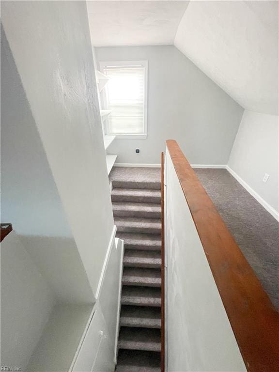 stairway with carpet and vaulted ceiling