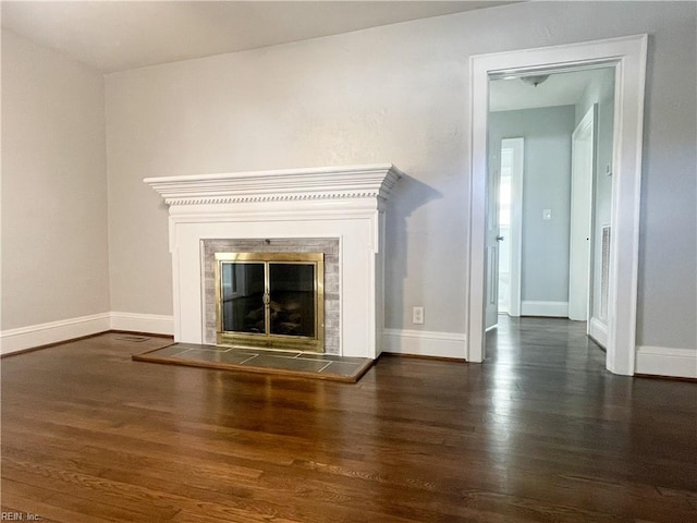 unfurnished living room with dark hardwood / wood-style flooring and a tile fireplace