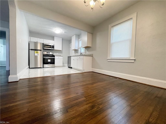 kitchen with white cabinetry, sink, an inviting chandelier, dark hardwood / wood-style floors, and appliances with stainless steel finishes