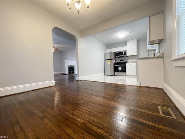 kitchen with ceiling fan, white cabinets, stainless steel appliances, and hardwood / wood-style flooring