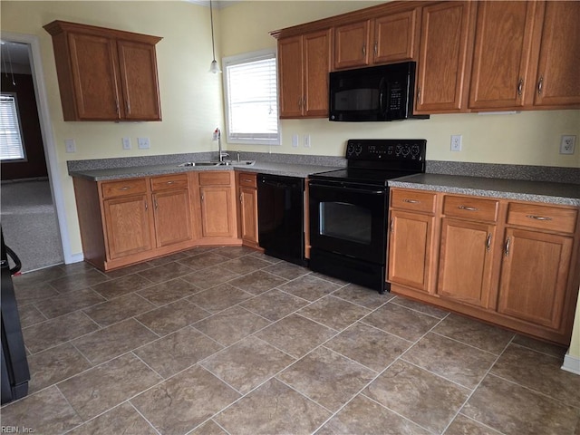 kitchen with hanging light fixtures, sink, black appliances, and dark tile patterned flooring