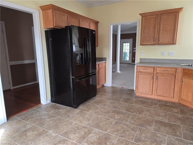 kitchen with tile patterned flooring, black fridge with ice dispenser, and ornamental molding