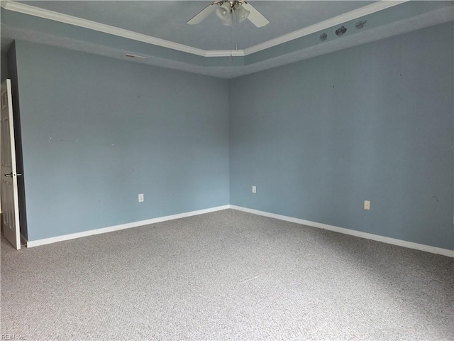 carpeted spare room featuring a tray ceiling, ceiling fan, and ornamental molding