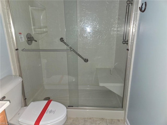 bathroom featuring tile patterned floors, toilet, and walk in shower