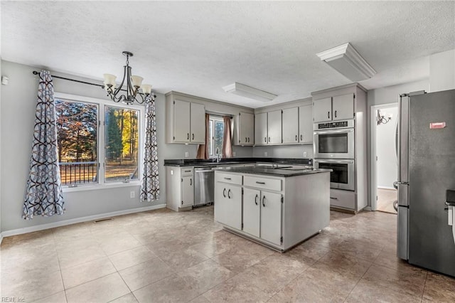 kitchen featuring a chandelier, appliances with stainless steel finishes, a textured ceiling, and gray cabinetry