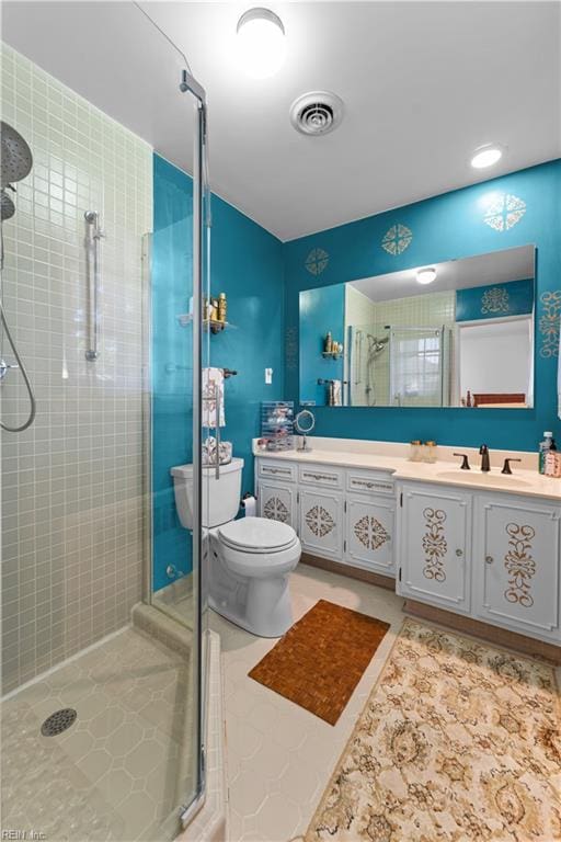 bathroom with tile patterned floors, vanity, toilet, and walk in shower