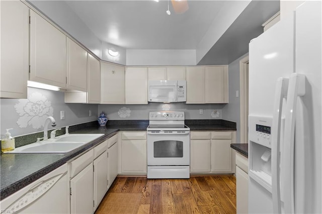 kitchen with sink, white cabinets, light hardwood / wood-style floors, and white appliances