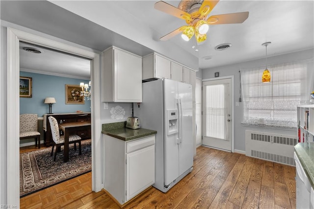 kitchen featuring radiator heating unit, white refrigerator with ice dispenser, white cabinets, ceiling fan with notable chandelier, and hardwood / wood-style flooring