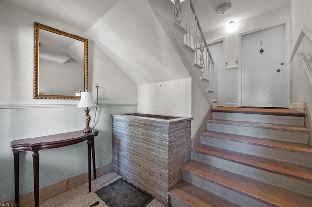 stairway featuring bar and lofted ceiling