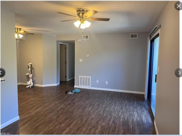 spare room with a textured ceiling, ceiling fan, and dark wood-type flooring