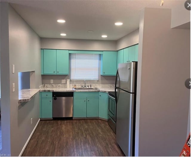 kitchen featuring light stone countertops, stainless steel appliances, dark wood-type flooring, and sink