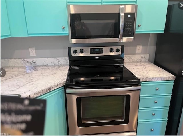 kitchen with blue cabinetry and stainless steel appliances