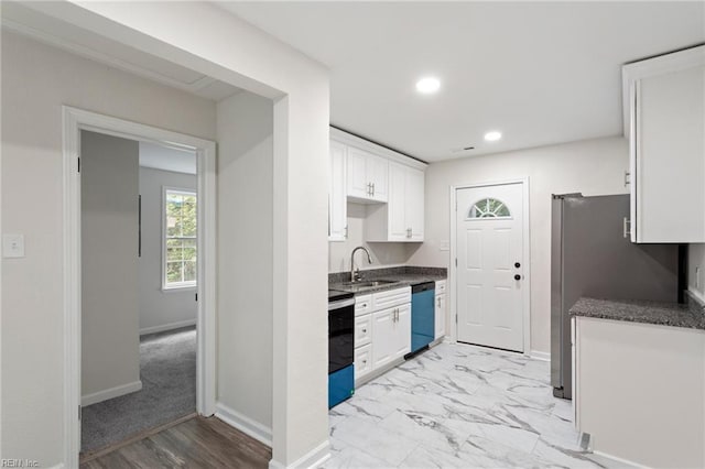 kitchen featuring dishwasher, stainless steel electric stove, sink, light colored carpet, and white cabinetry