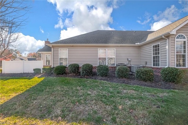 view of side of home with a lawn and central AC unit