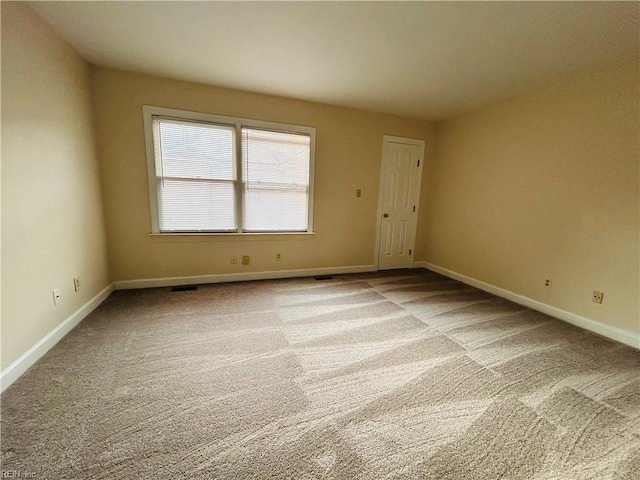 unfurnished room with light carpet and baseboards