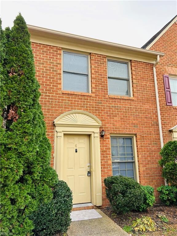 doorway to property featuring brick siding