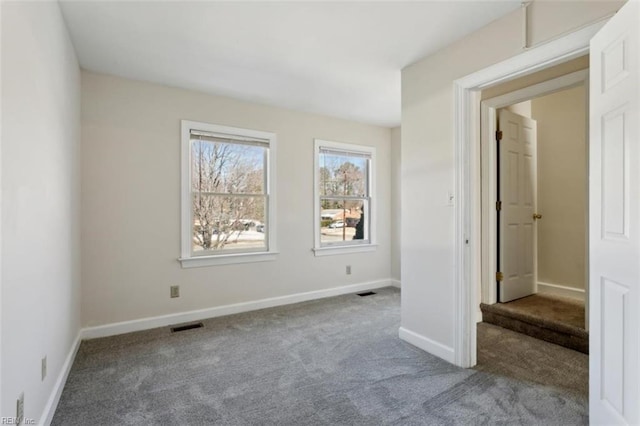 unfurnished bedroom featuring carpet floors, visible vents, and baseboards