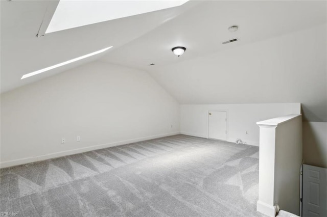 additional living space featuring vaulted ceiling, carpet flooring, and visible vents