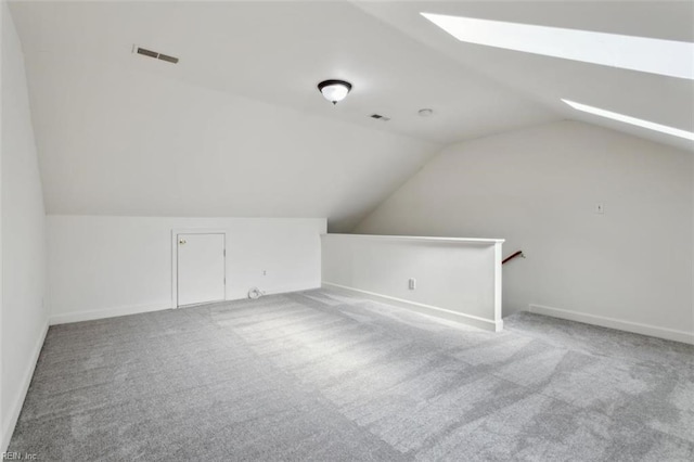 bonus room featuring vaulted ceiling with skylight, carpet floors, and visible vents