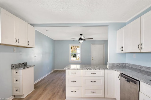 kitchen with kitchen peninsula, light wood-type flooring, stainless steel dishwasher, ceiling fan, and white cabinets