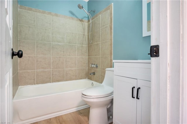 full bathroom with vanity, hardwood / wood-style flooring, toilet, and tiled shower / bath