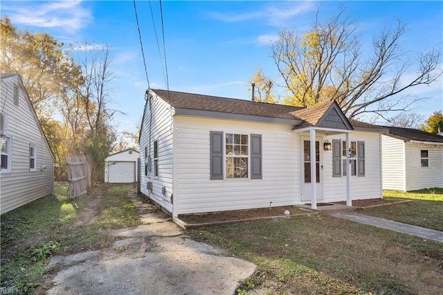 bungalow-style house featuring an outbuilding, a garage, and a front lawn