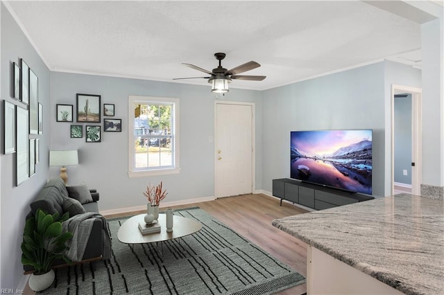 living room with ceiling fan, light hardwood / wood-style floors, and ornamental molding