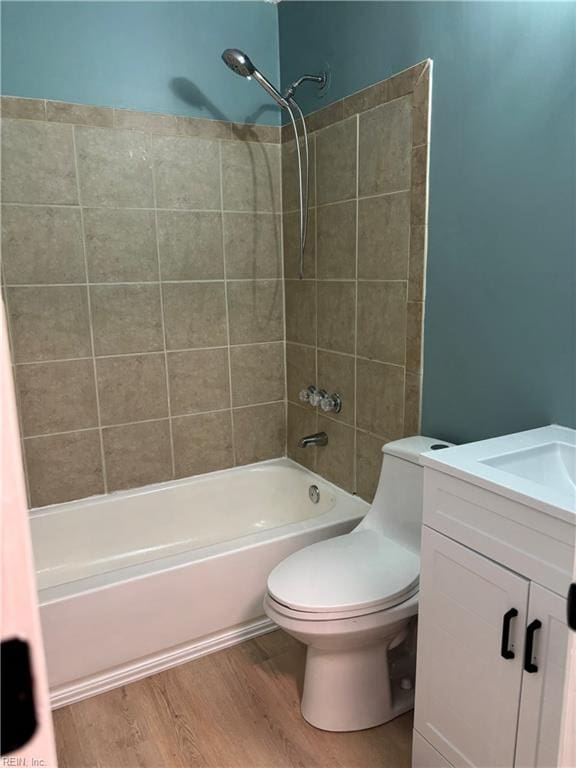 full bathroom with vanity, wood-type flooring, tiled shower / bath combo, and toilet