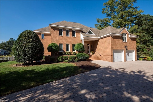 colonial inspired home featuring a garage and a front yard