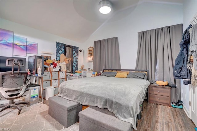 bedroom with hardwood / wood-style flooring, ceiling fan, and lofted ceiling