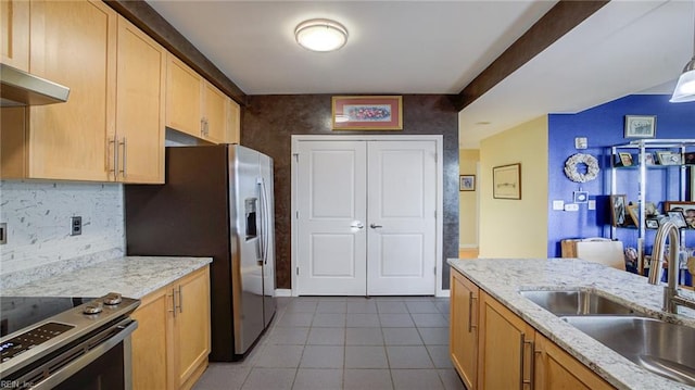 kitchen featuring tile patterned floors, sink, light brown cabinetry, light stone counters, and stainless steel appliances