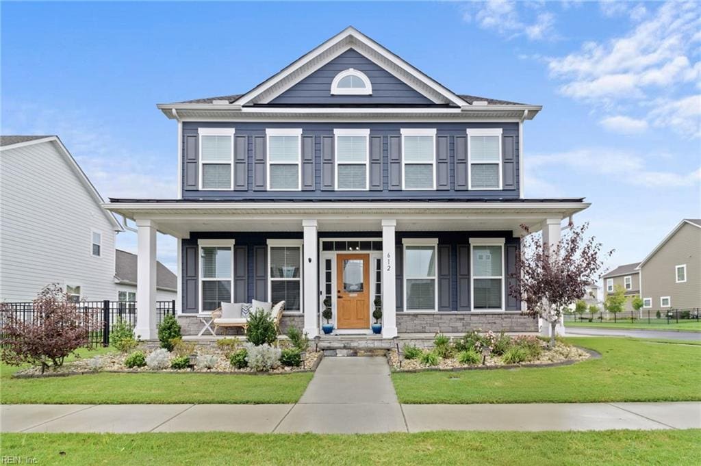 view of front of home with a porch and a front yard