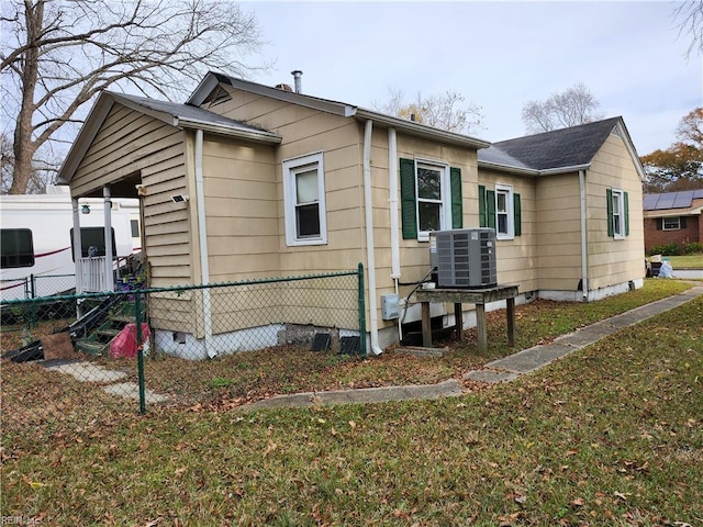 view of side of property featuring a yard and central AC