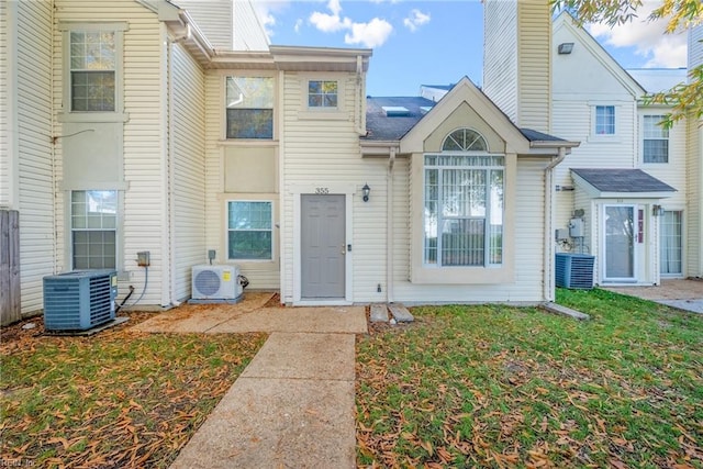 exterior space with ac unit, cooling unit, and a yard