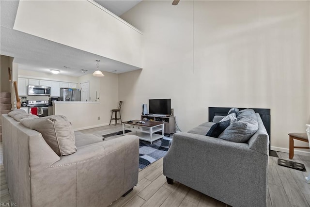 living room featuring light hardwood / wood-style floors and a towering ceiling