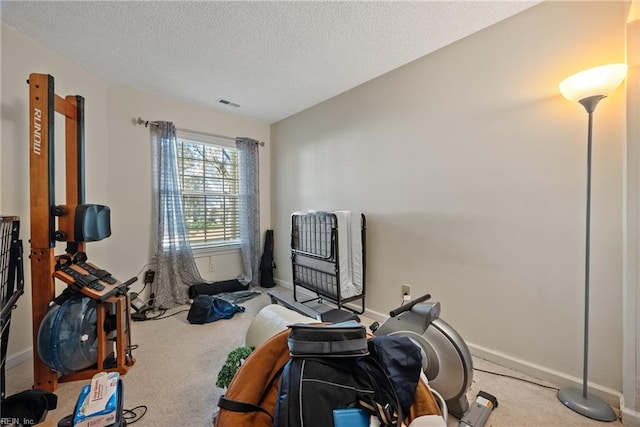 workout room with carpet flooring and a textured ceiling