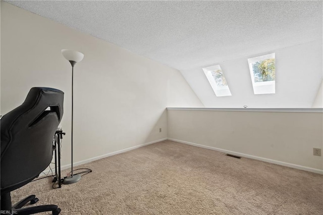 unfurnished office featuring light carpet, a textured ceiling, and vaulted ceiling