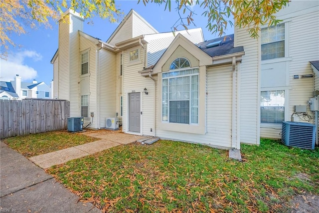 view of front of house featuring central AC, ac unit, and a front lawn