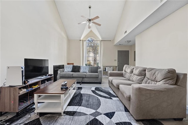 living room featuring ceiling fan, hardwood / wood-style floors, and high vaulted ceiling