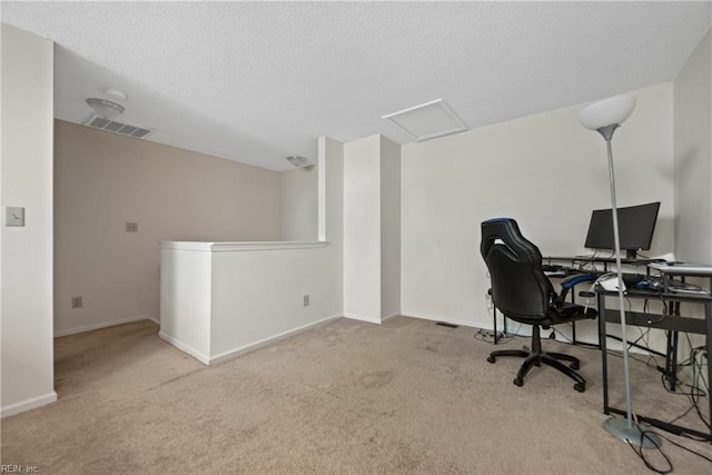 carpeted office space with a textured ceiling