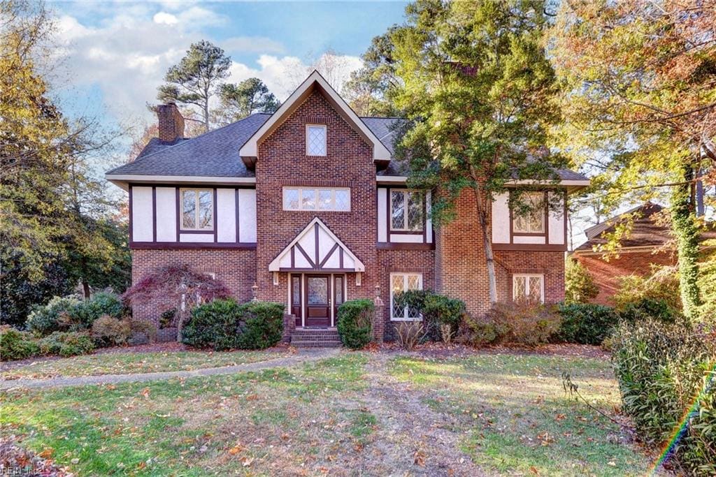 tudor home featuring a front lawn