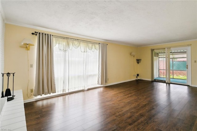 spare room with ornamental molding, a textured ceiling, and dark wood-type flooring