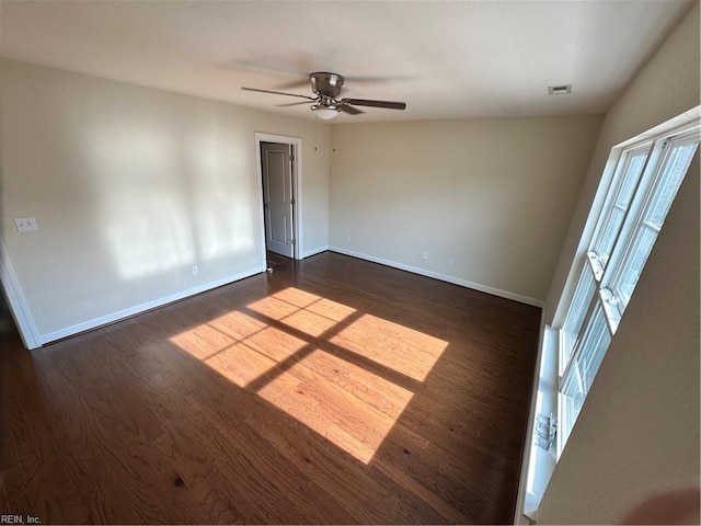 empty room with ceiling fan and dark wood-type flooring