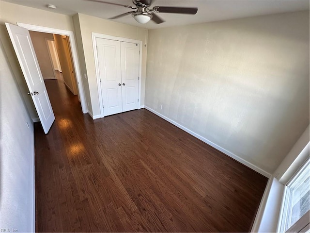 unfurnished bedroom featuring a closet, ceiling fan, and dark hardwood / wood-style flooring