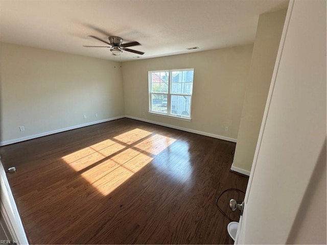 empty room with dark hardwood / wood-style floors and ceiling fan